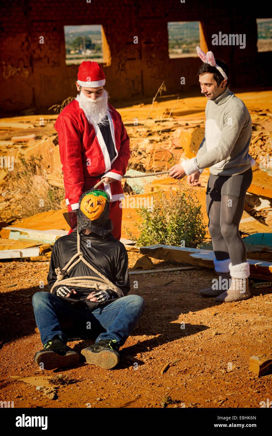 Halloween monster being taken prisoner by Santa and the Easter bunny Stock Photo