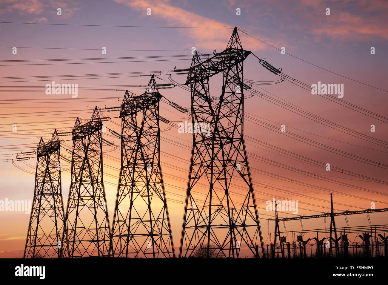 high voltage pylons silhouette cloudy sky background Stock Photo - Alamy