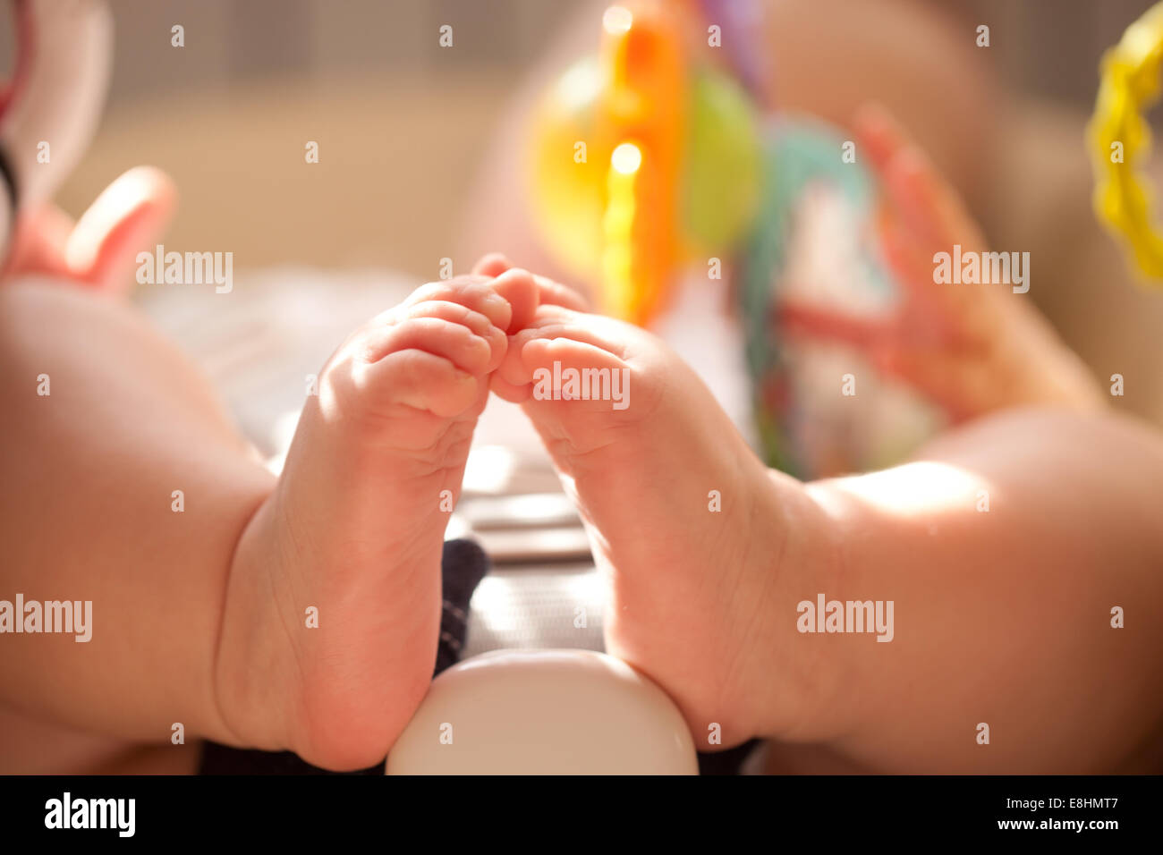 Baby feet close up. Kid playing with toys in the baby chair Stock Photo