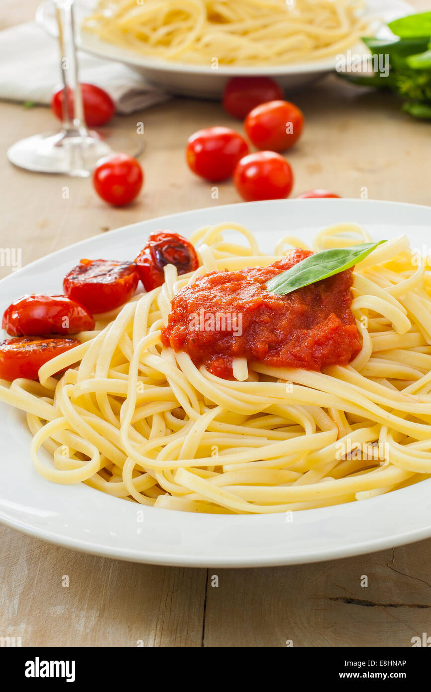 Two plates of spaghetti with tomato and basil Stock Photo