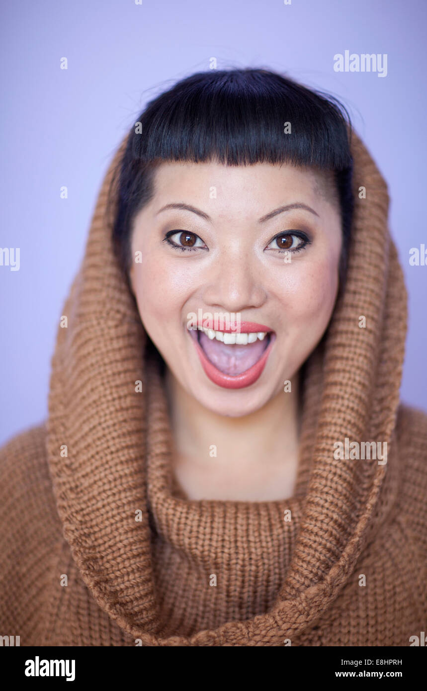 Asian woman with warm fuzzy cowl neck sweater on. Short hair cut with cute bangs. Stock Photo