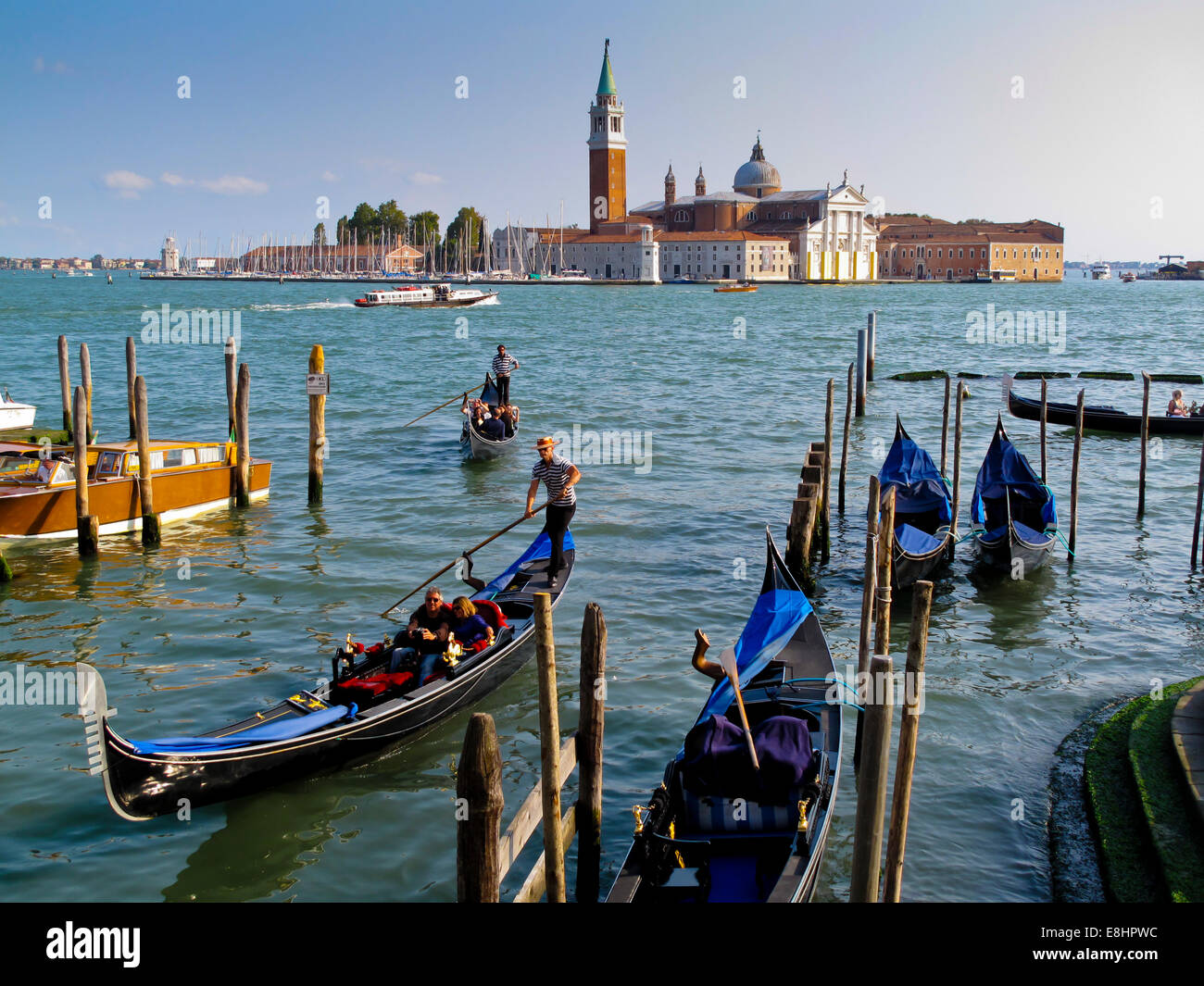 Traditional Venetian gondolas in Bacino di San Marco with San Giorgio Maggiore visible across the water in Venice Northern Italy Stock Photo