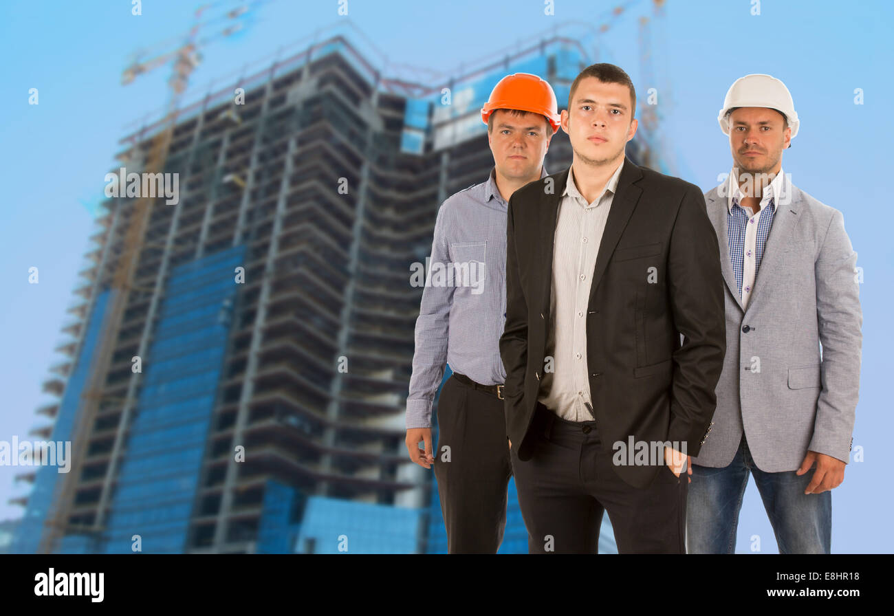 Group of three engineers and architects in their hardhats standing ...