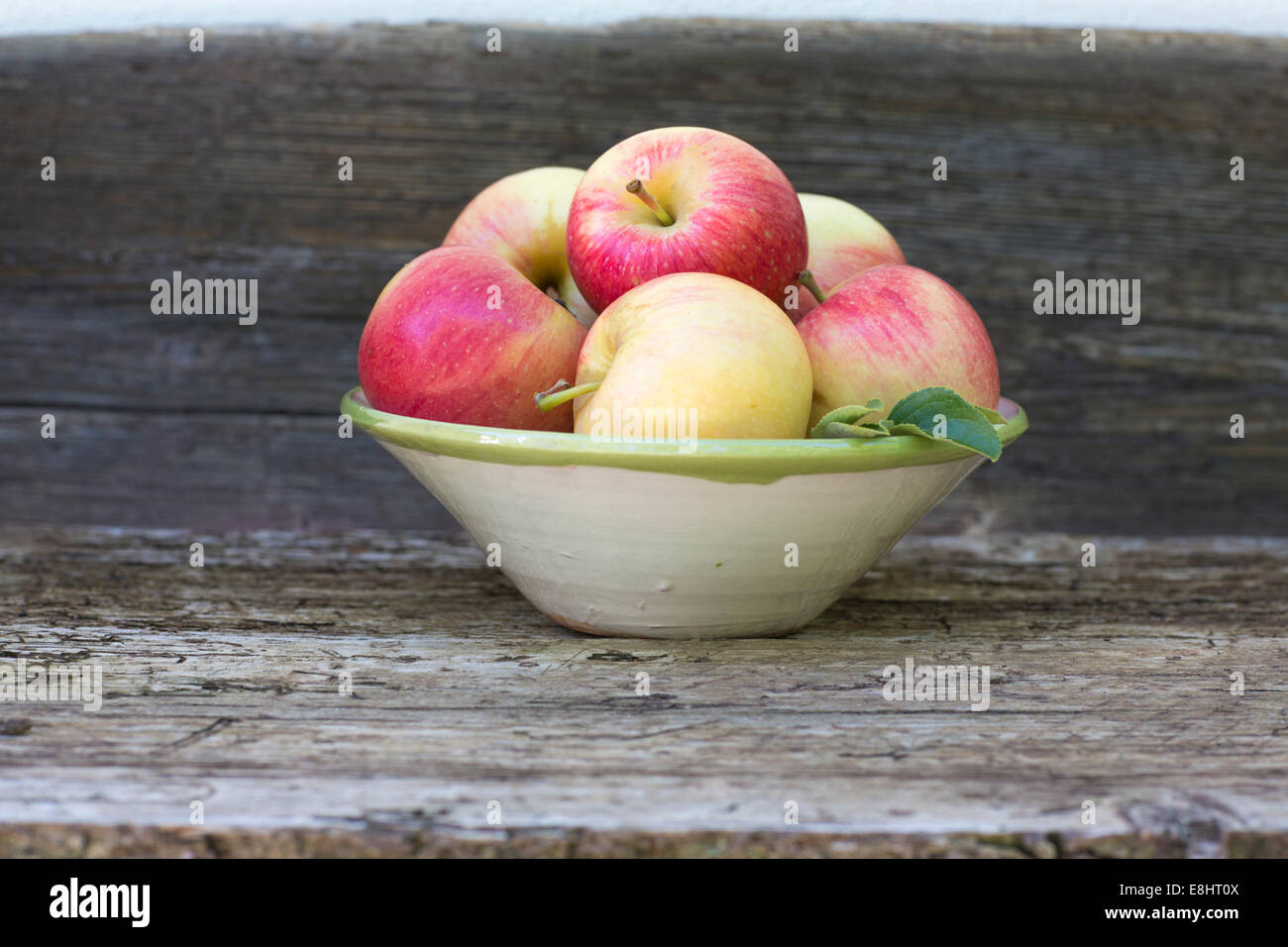 apples, red, green, fruit, autumn, rustic bench, white background, outdoors, in hand painted ceramic bowl,  juicy, fresh, health Stock Photo