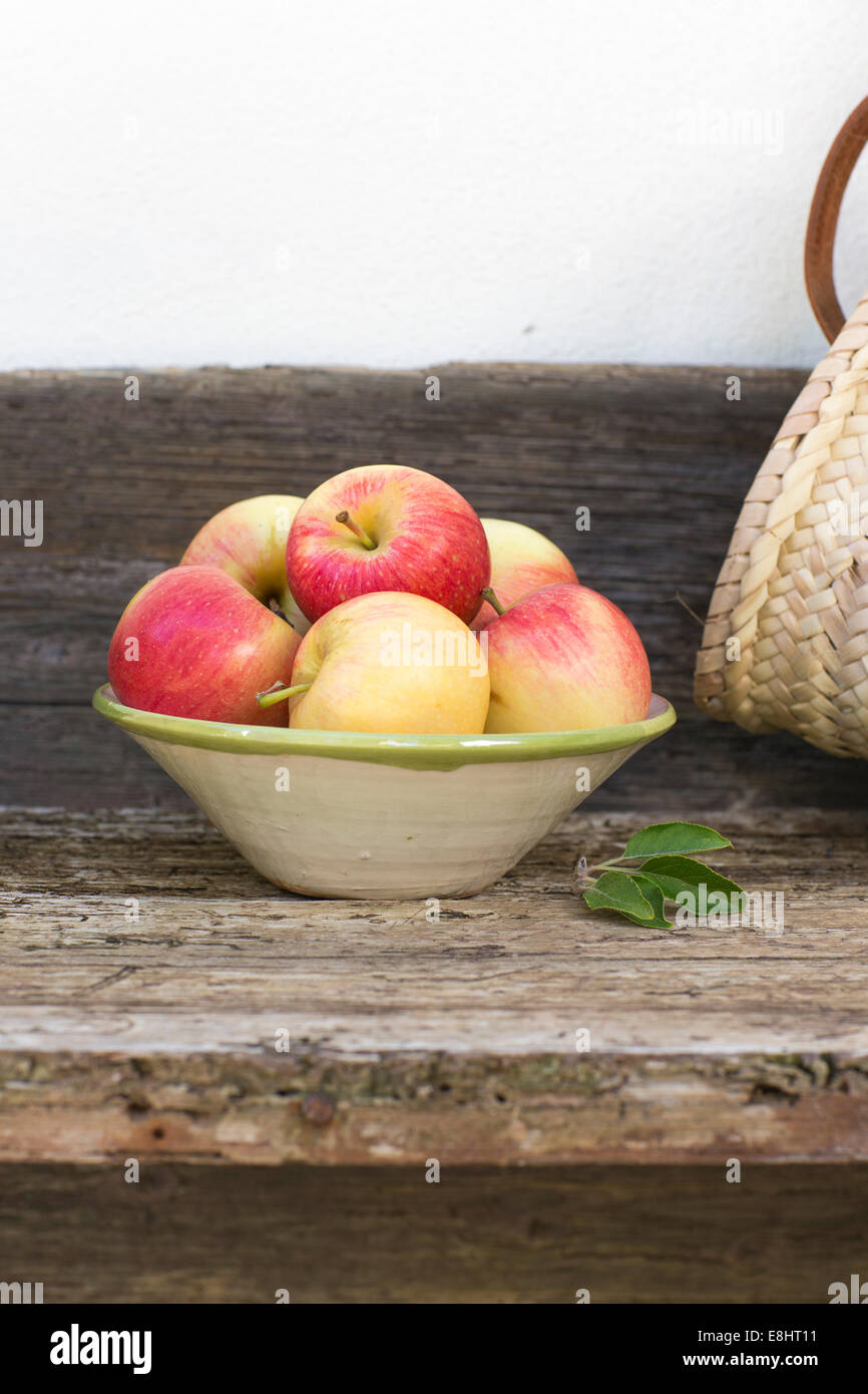 apples, red, green, fruit, autumn, rustic bench, white background, outdoors, in hand painted ceramic bowl,  juicy, fresh, health Stock Photo