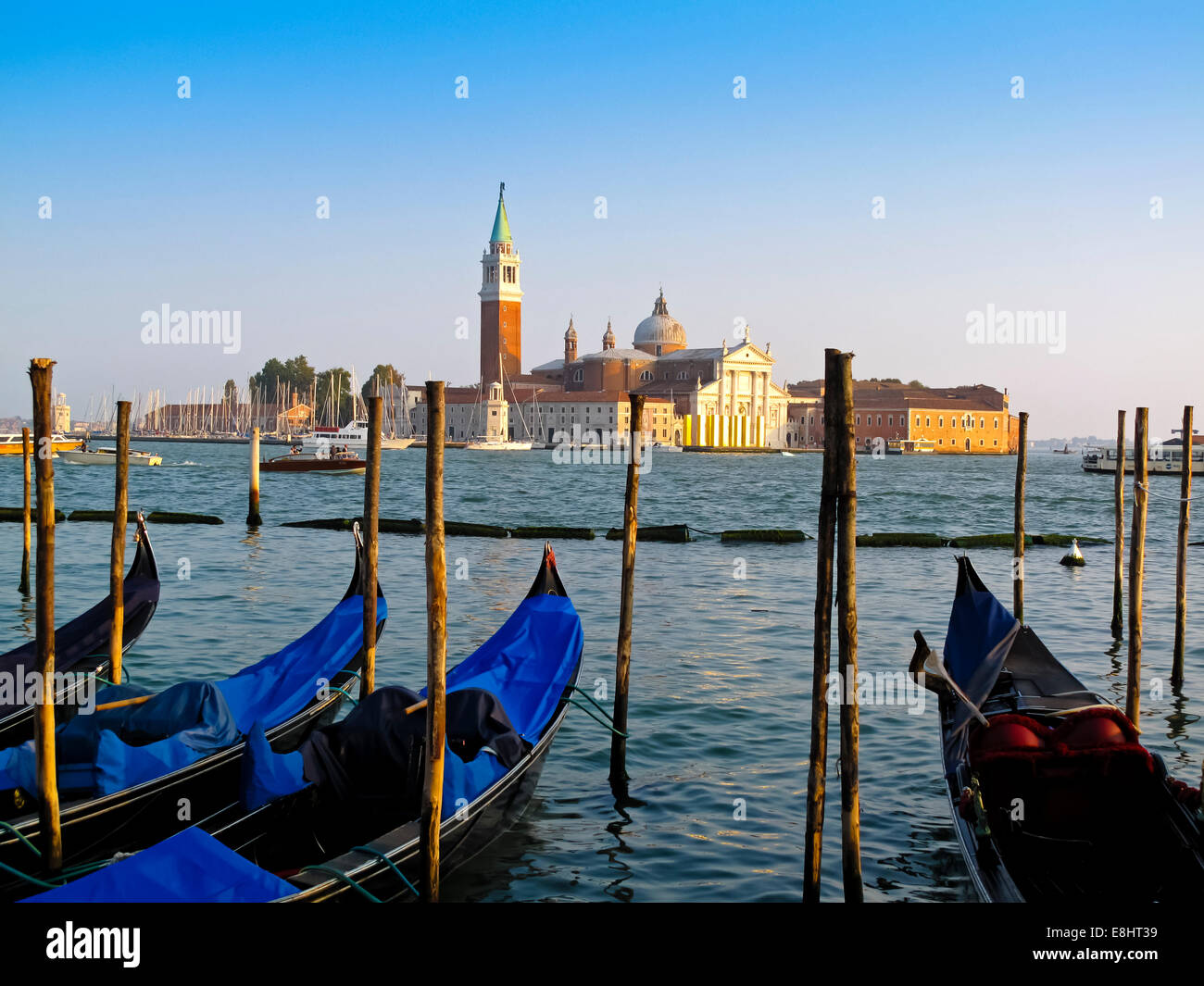 Traditional Venetian gondolas in Bacino di San Marco with San Giorgio Maggiore visible across the water in Venice Northern Italy Stock Photo