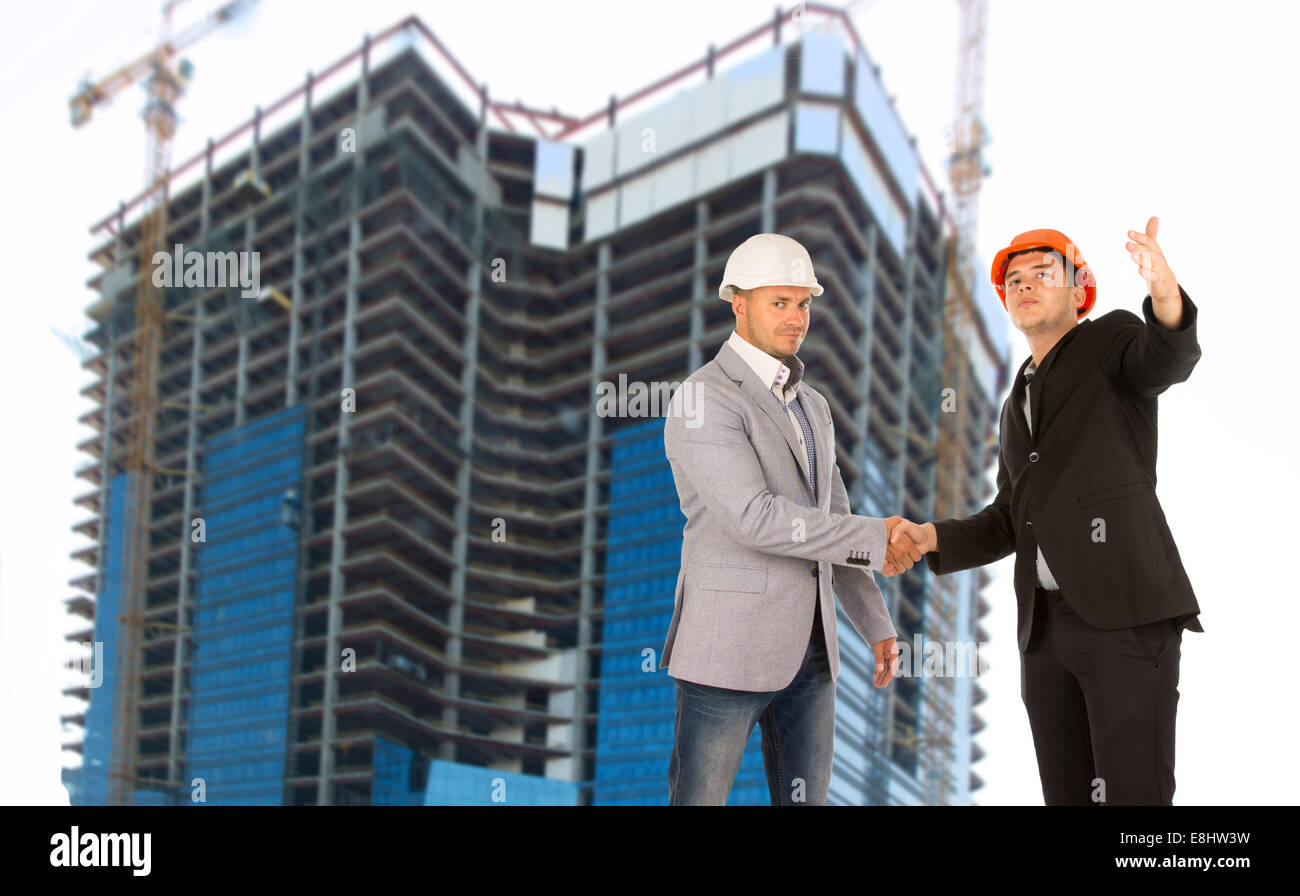 Architect and structural engineer shaking hands on a building site