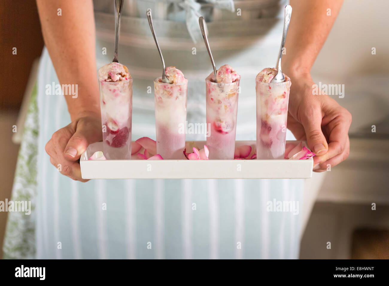 raspberry ripple ice cream in shot glasses held in hands on tray Stock Photo