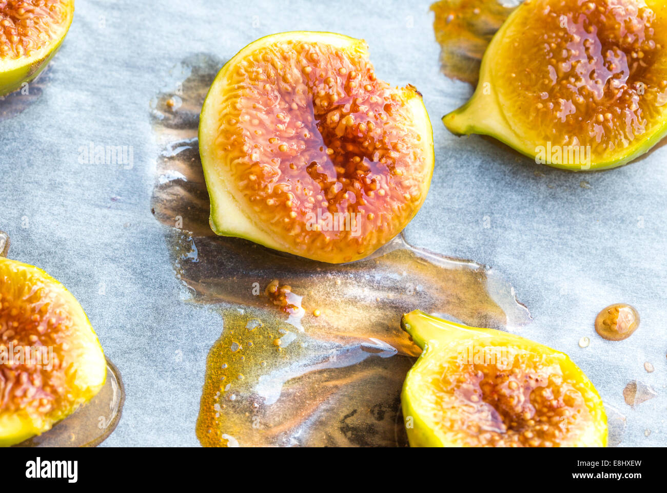 oven roasted green figs on baking paper showing drizzled honey Stock Photo