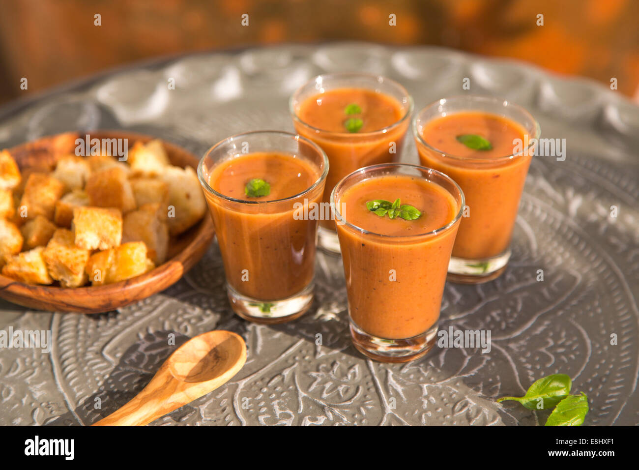 outdoors shot of tomato gazpacho or soup in glasses with basil on metal tray Stock Photo