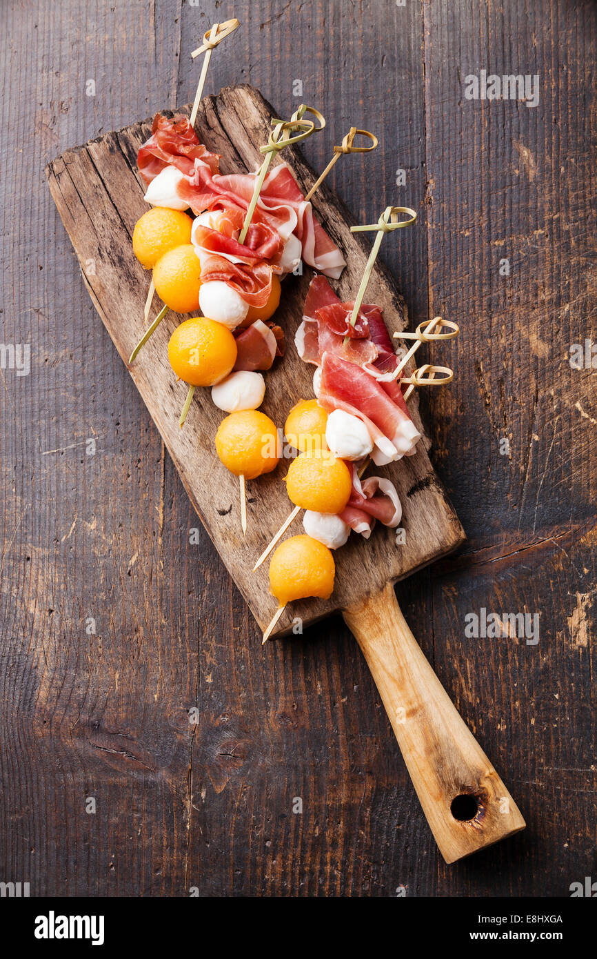 Mozzarella, prosciutto, melon canapes on dark wooden background Stock Photo Alamy