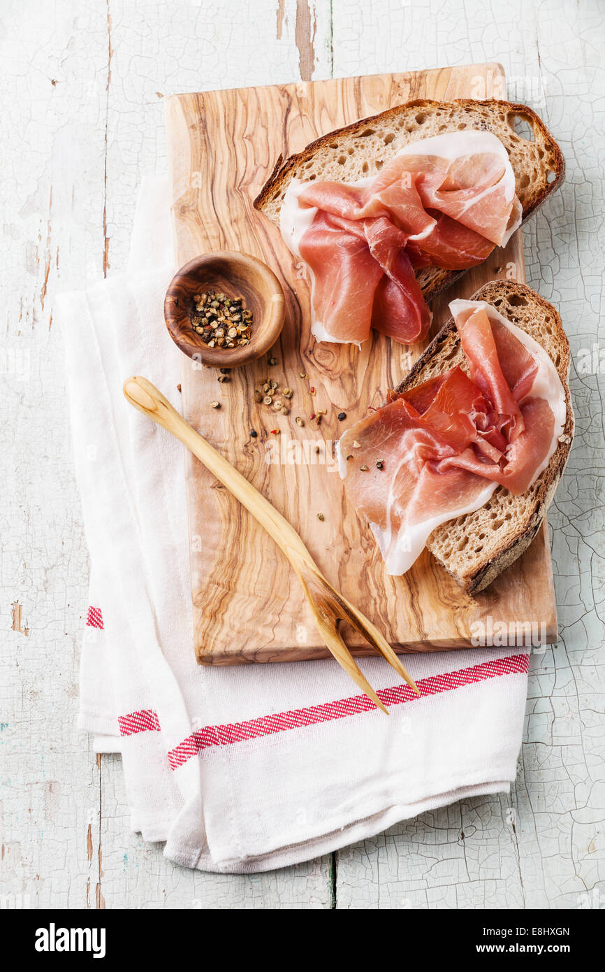 Bruschettas with ham on bread on blue wooden background Stock Photo