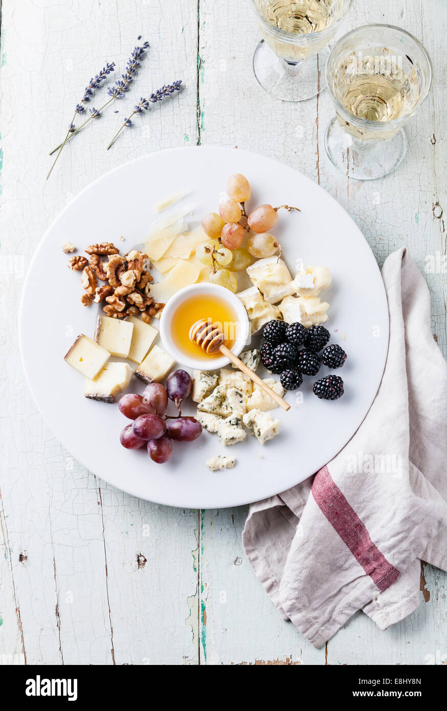 Cheese plate Assortment of various types of cheese and honey on white plate Stock Photo