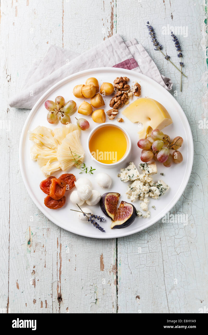 Cheese plate Assortment of various types of cheese and honey on white plate Stock Photo