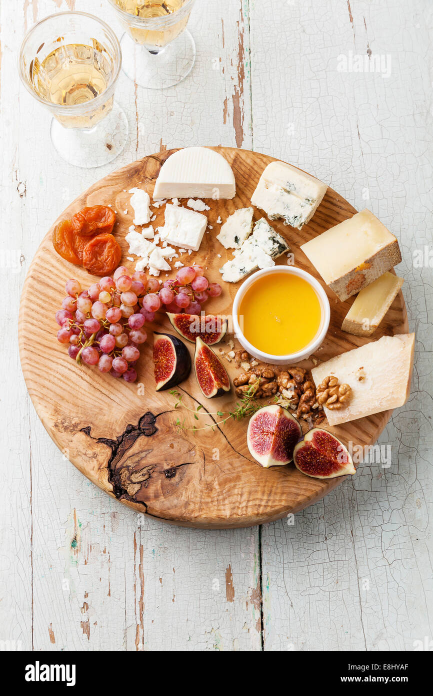 Cheese plate Assortment of various types of cheese on wooden cutting board Stock Photo
