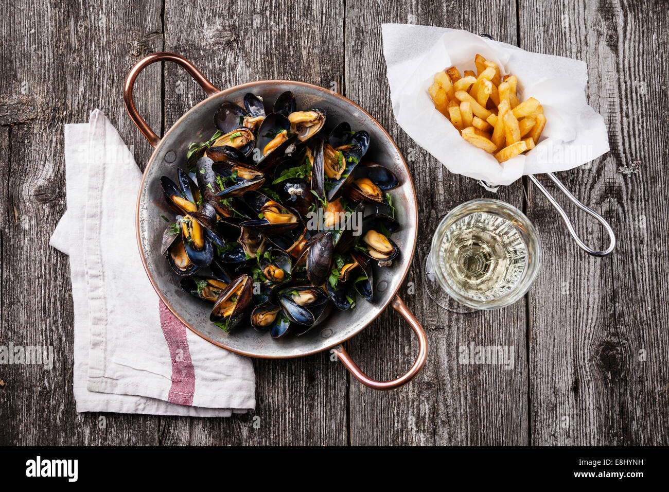 Mussels, french fries and wine on dark wooden background Stock Photo