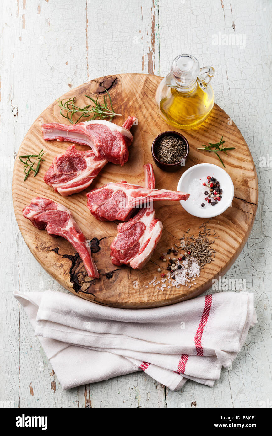 Raw fresh lamb ribs with salt, pepper and cumin on wooden cutting board