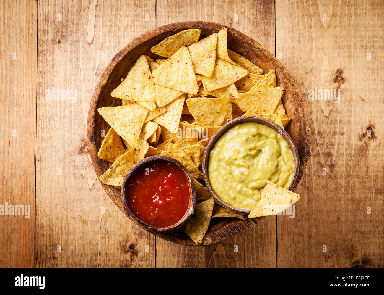 Fresh salsa and guacamole dips with nachos chips on wooden background Stock Photo