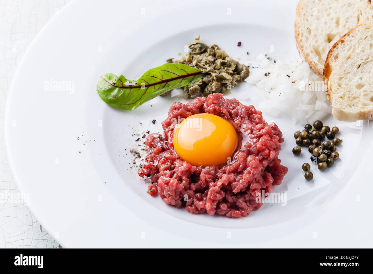 Beef tartare with capers and bread on white plate Stock Photo