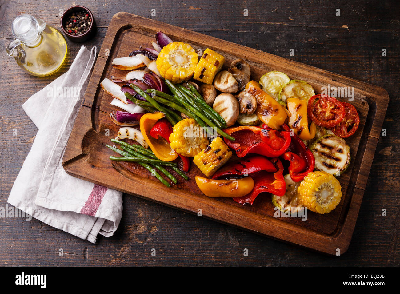 Grilled vegetables on cutting board on dark wooden background Stock Photo