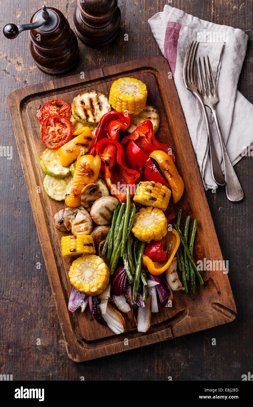 Grilled vegetables on cutting board on dark wooden background Stock Photo