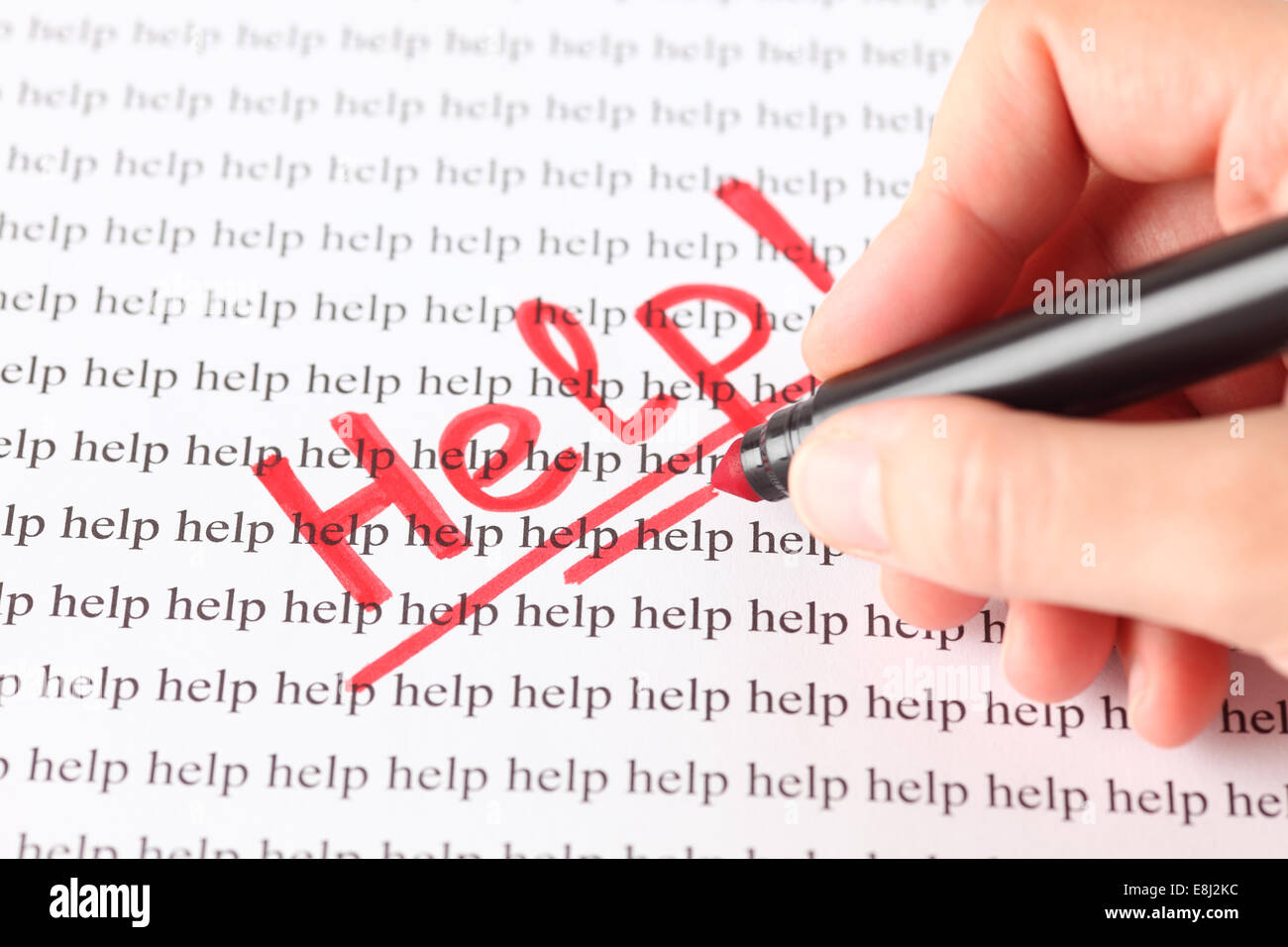 Woman's hand with red pen writing word 