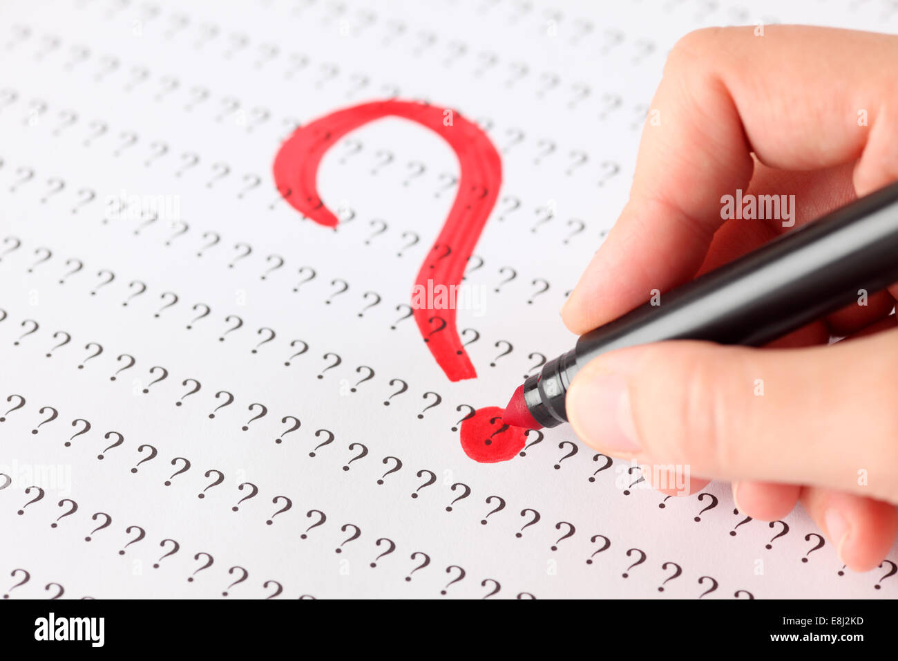Woman's hand with red pen writing Question mark on the background of ...