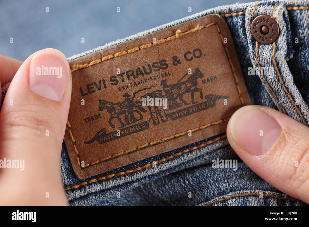 Tambov, Russian Federation - October 21, 2012: Woman's hands holding label logo of a pair Levi's Jeans. Stock Photo
