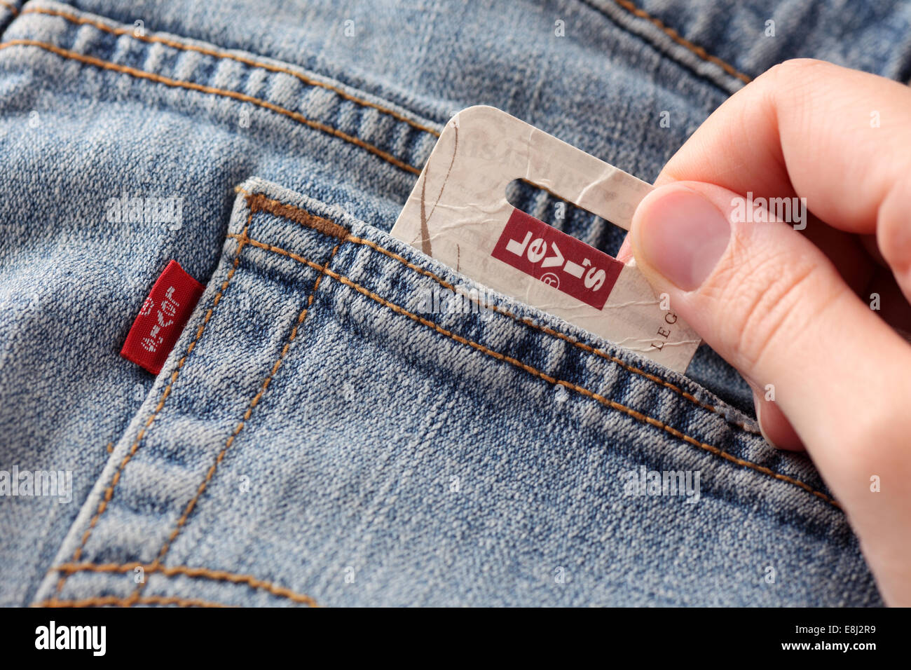 Tambov, Russian Federation - October 21, 2012: Woman's hand taking out label logo  from pocket of a pair Levi's Jeans. Stock Photo