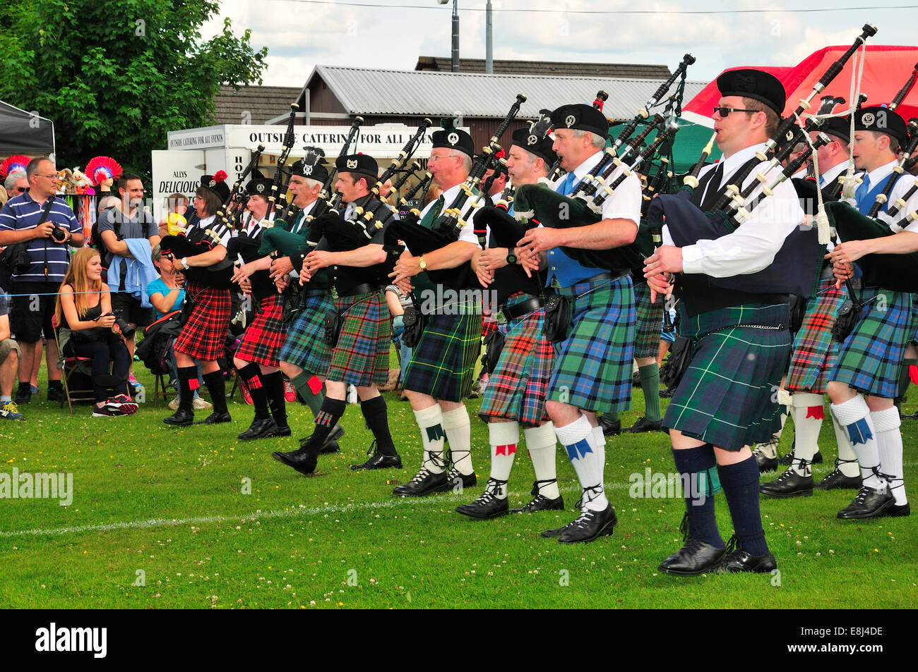 Pipe band marching in unison on the sports ground at the Highland Games, Dufftown, Moray, Highlands, Scotland, United Kingdom Stock Photo