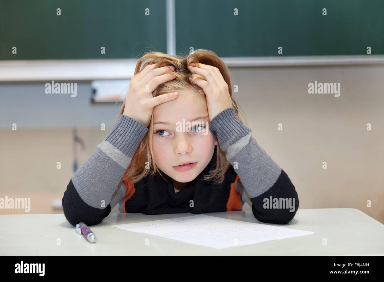 Schoolgirl, 9 years, struggling during a difficult exam Stock Photo