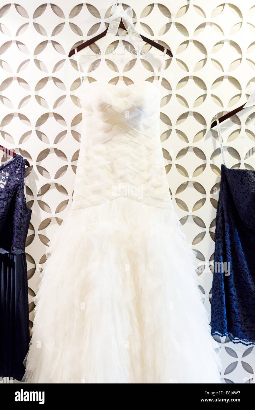 Wedding dress hanging on a white wall with pattern Stock Photo - Alamy