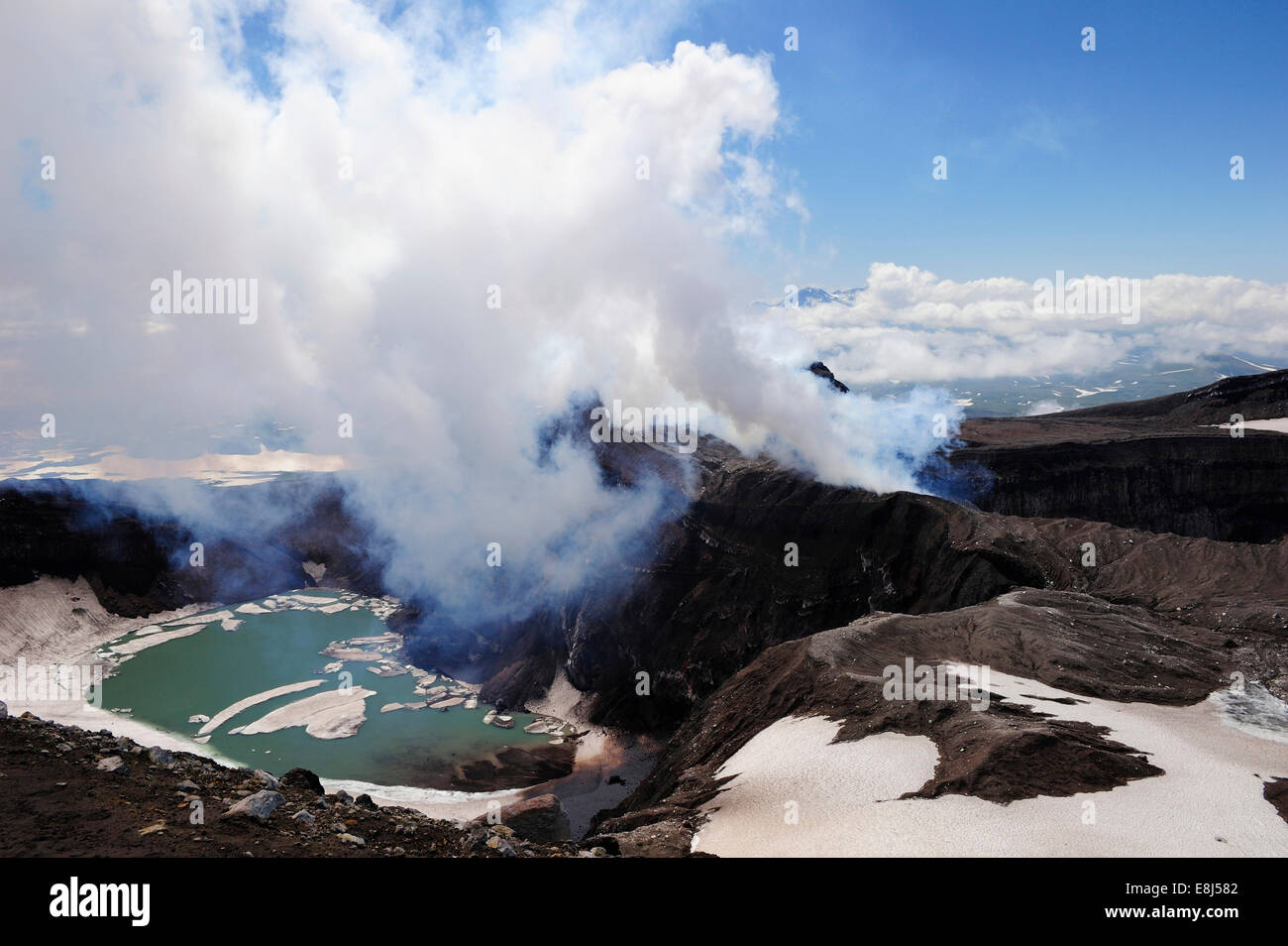Volcanic crater with crater lake and a hot water vapour cloud, Gorely volcano, Kamchatka Peninsula, Russia Stock Photo