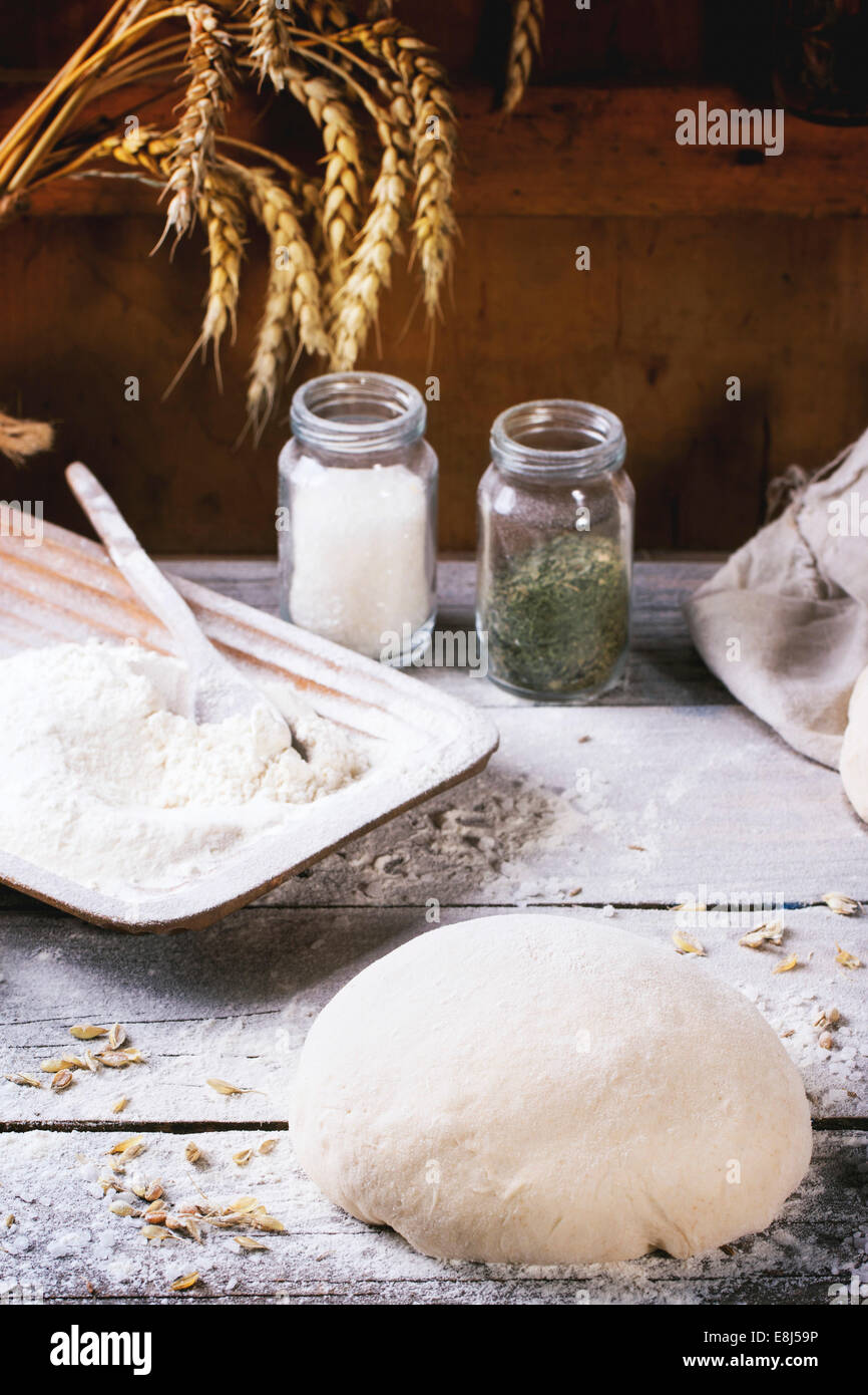 Baking bread. Dough on wooden table with flour, rollingpin and jars