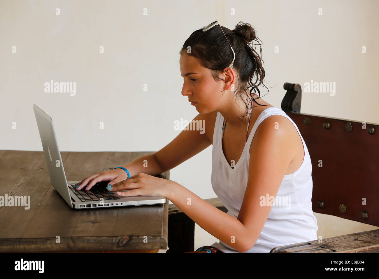 Teenager using a laptop in a Cordoba hotel Stock Photo