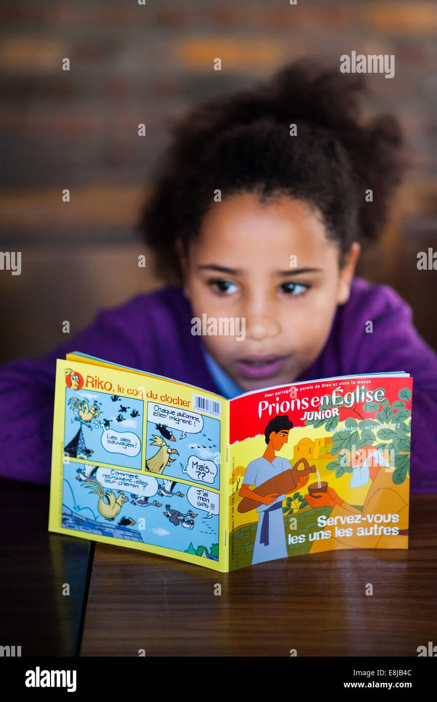 Girl reading a catholic children's book in church Stock Photo Alamy