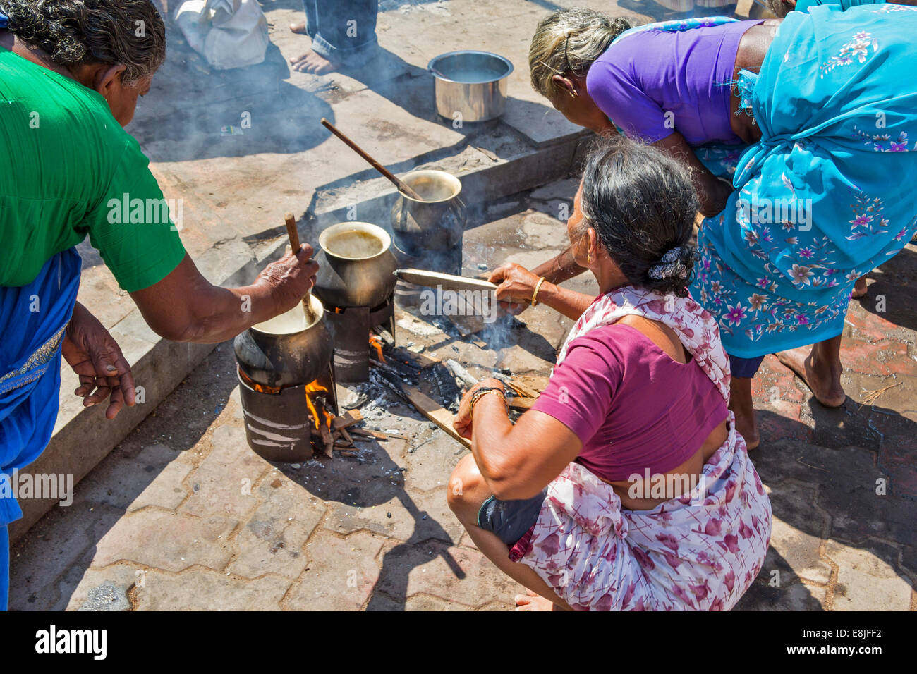 PILGRIMS COOKING FOOD OVER OPEN FIRES OUTSIDE THE  MEENAKSHI AMMAN TEMPLE MADURAI INDIA Stock Photo