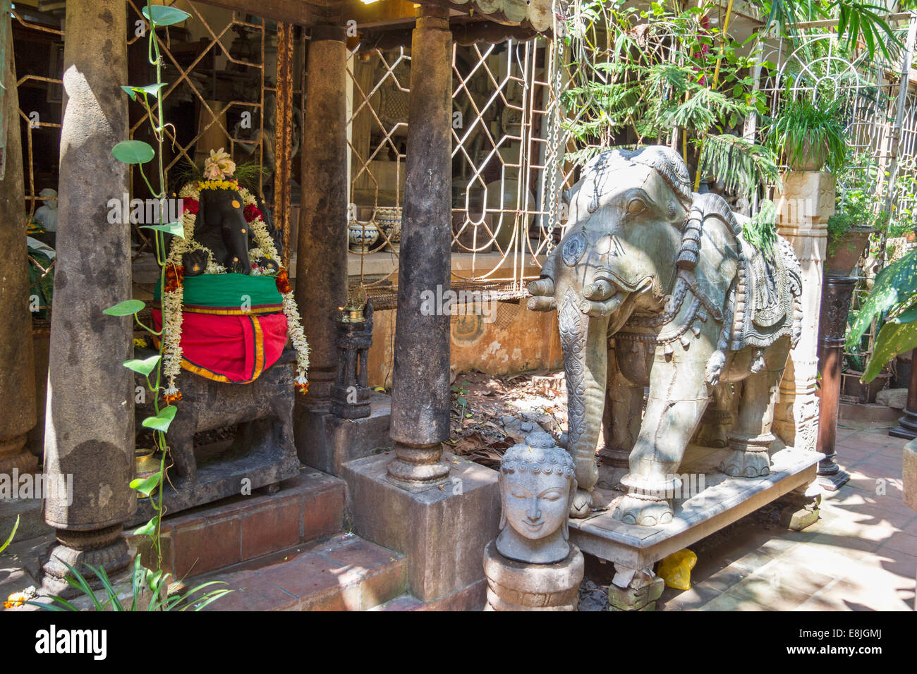 PONDICHERRY INDIA A YARD WITH ANTIQUE STATUES OF ELEPHANT AND SHRINE WITH THE ELEPHANT GOD GANESH Stock Photo