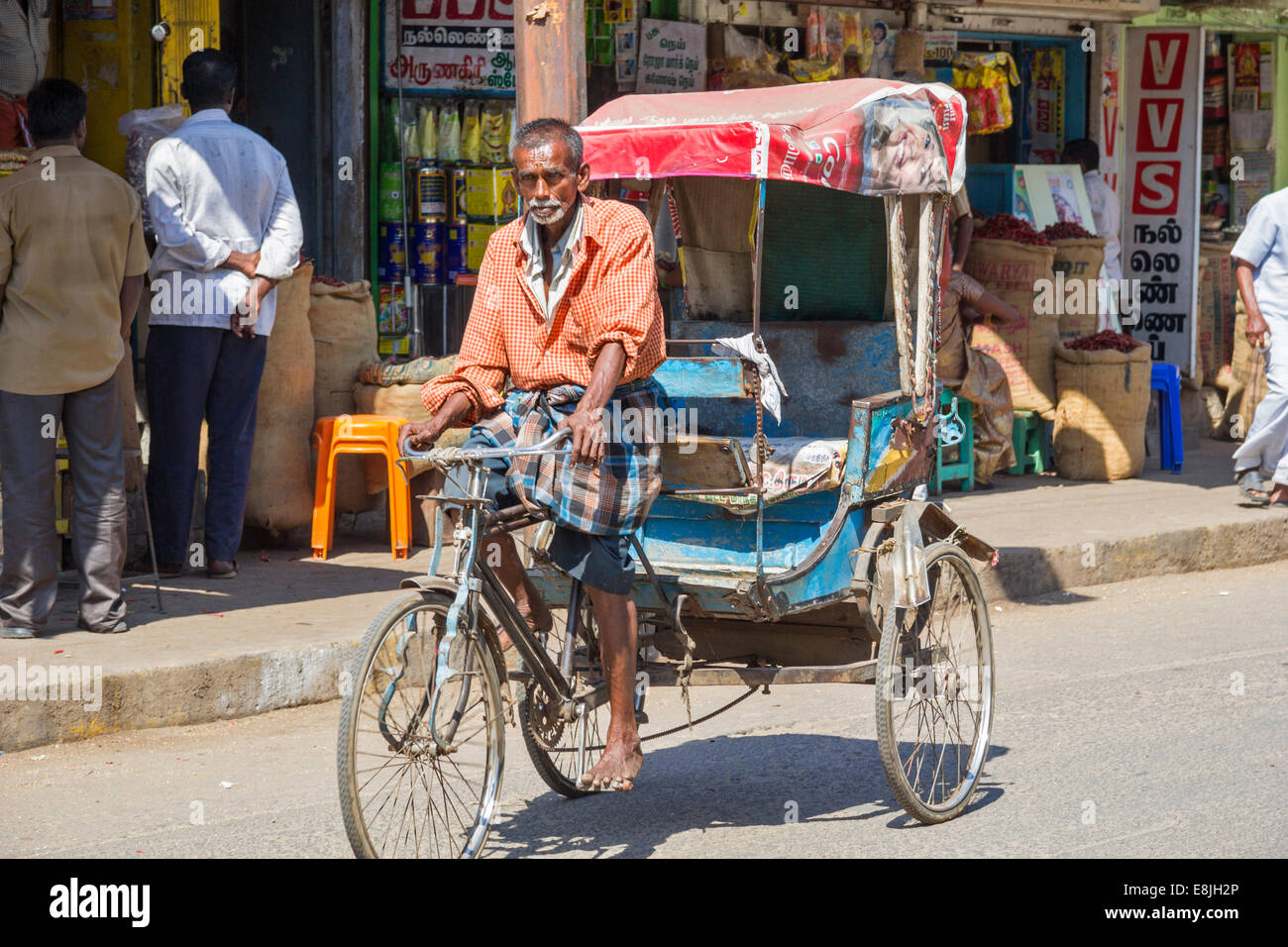 RICKSHAW DRIVER LOOKING FOR ANOTHER VERY HEAVY LOAD INDIA Stock Photo