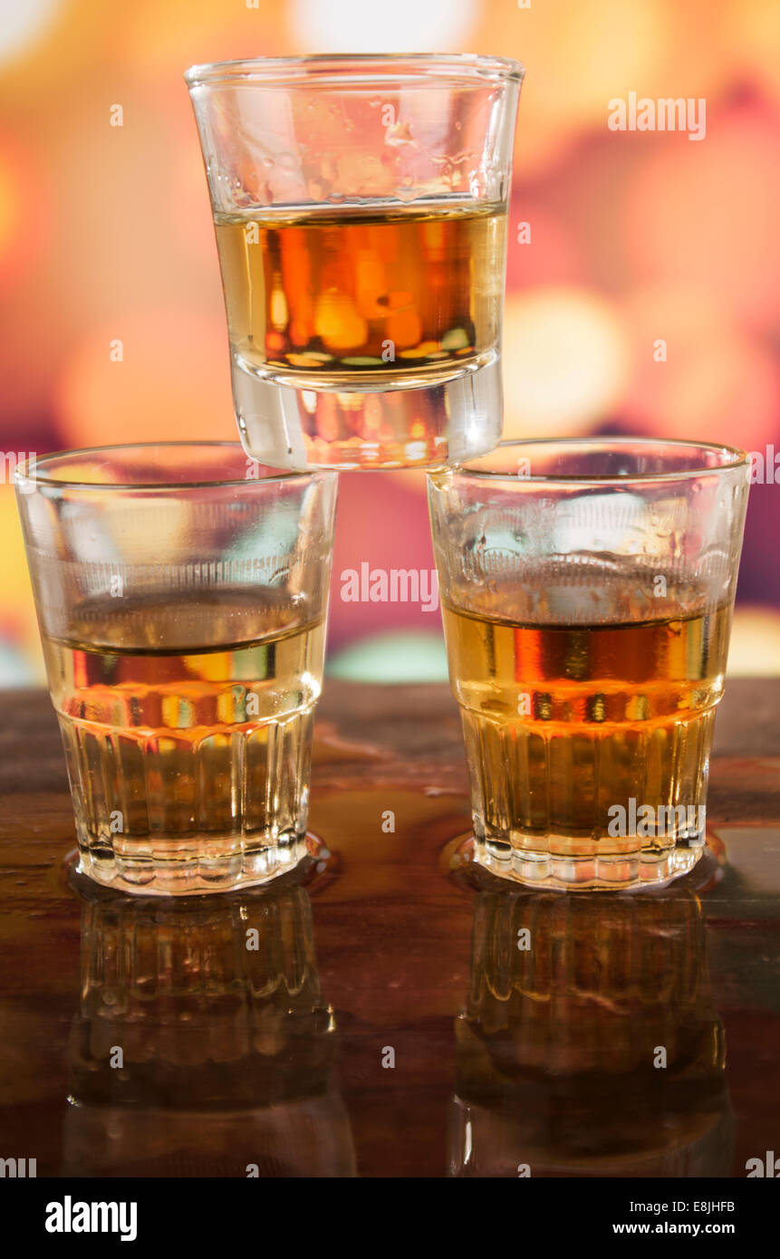 glass of rum whiskey over defocused lights background Stock Photo Alamy