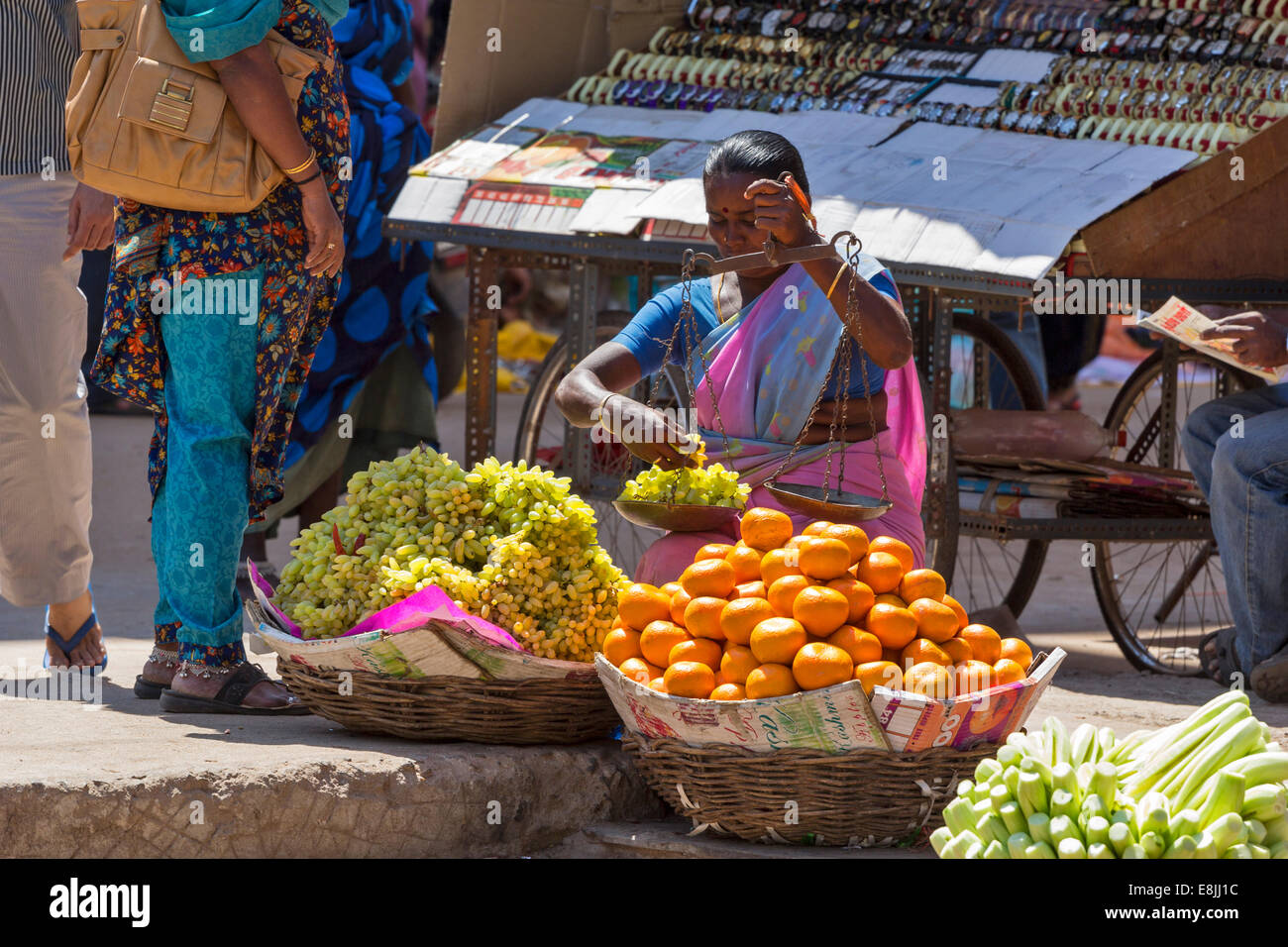 STREET SELLER INDIA WEIGHING THE  GRAPES ON HAND HELD SCALES Stock Photo