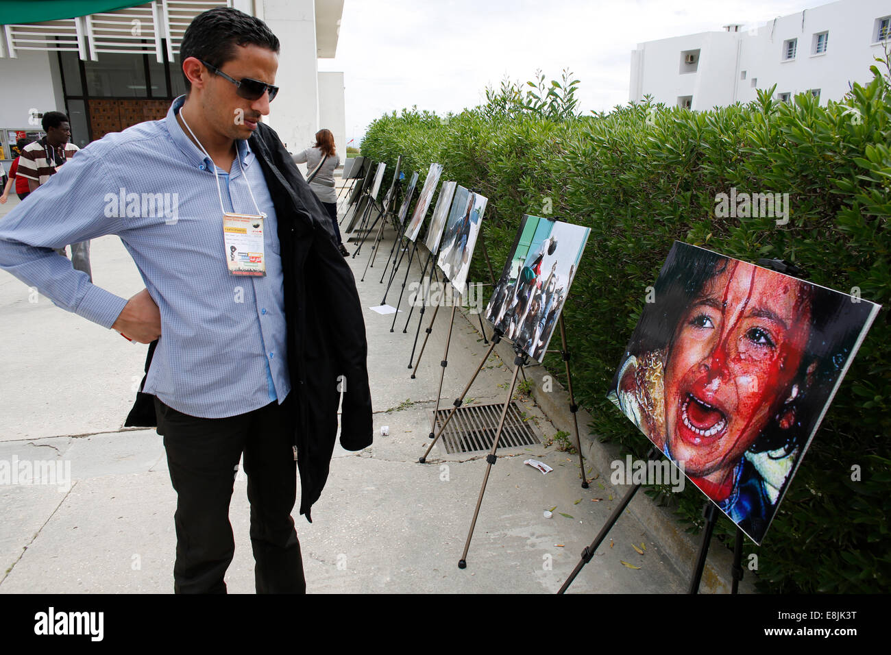 Man looking at a gruesome photograph at the World Social Forum in Tunis Stock Photo