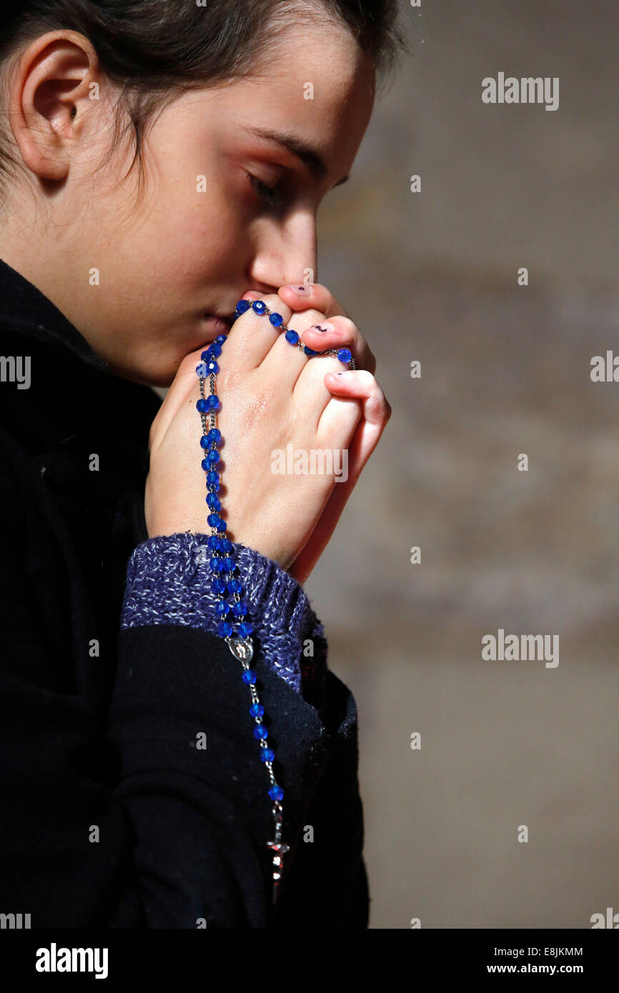 Teenager praying with a rosary Stock Photo - Alamy