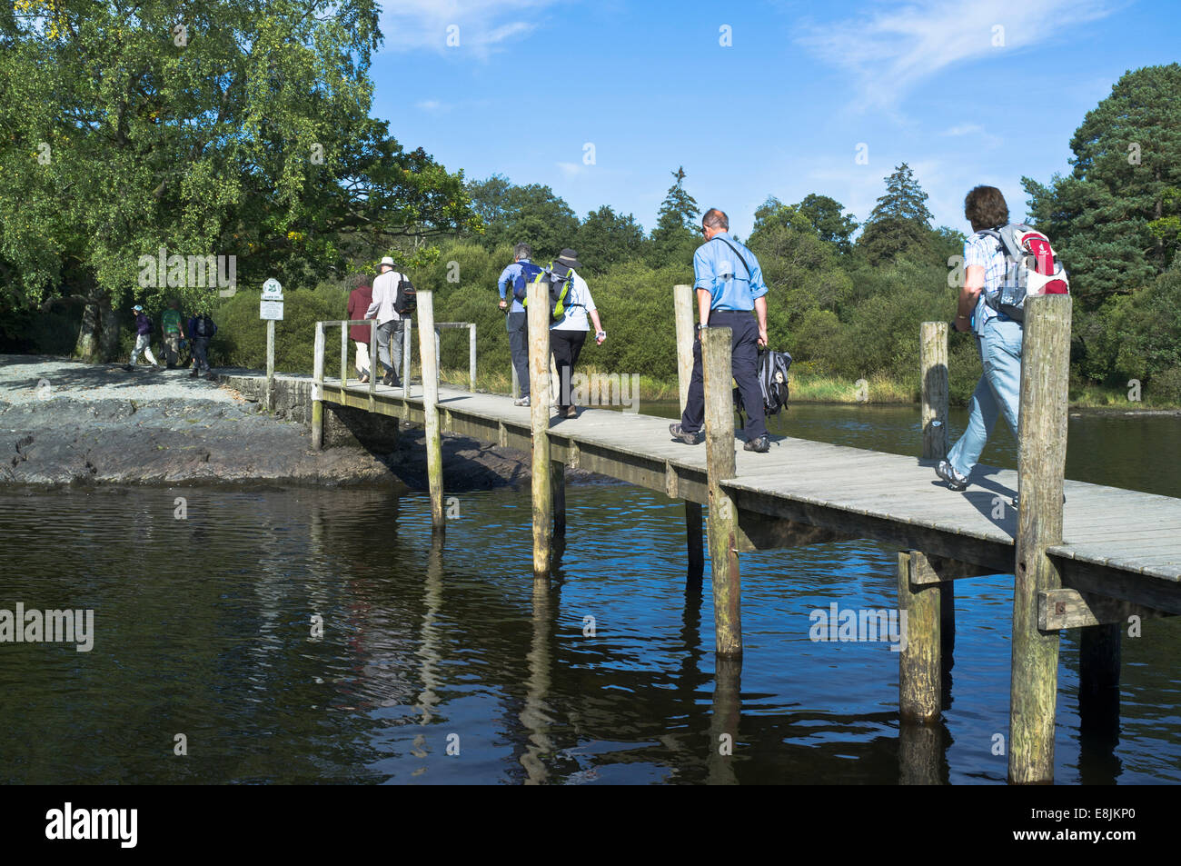 dh Derwent Water national park UK KESWICK LAKE DISTRICT Tourist hikers walking Hawes End landing stage jetty cumbria england people group hiking Stock Photo