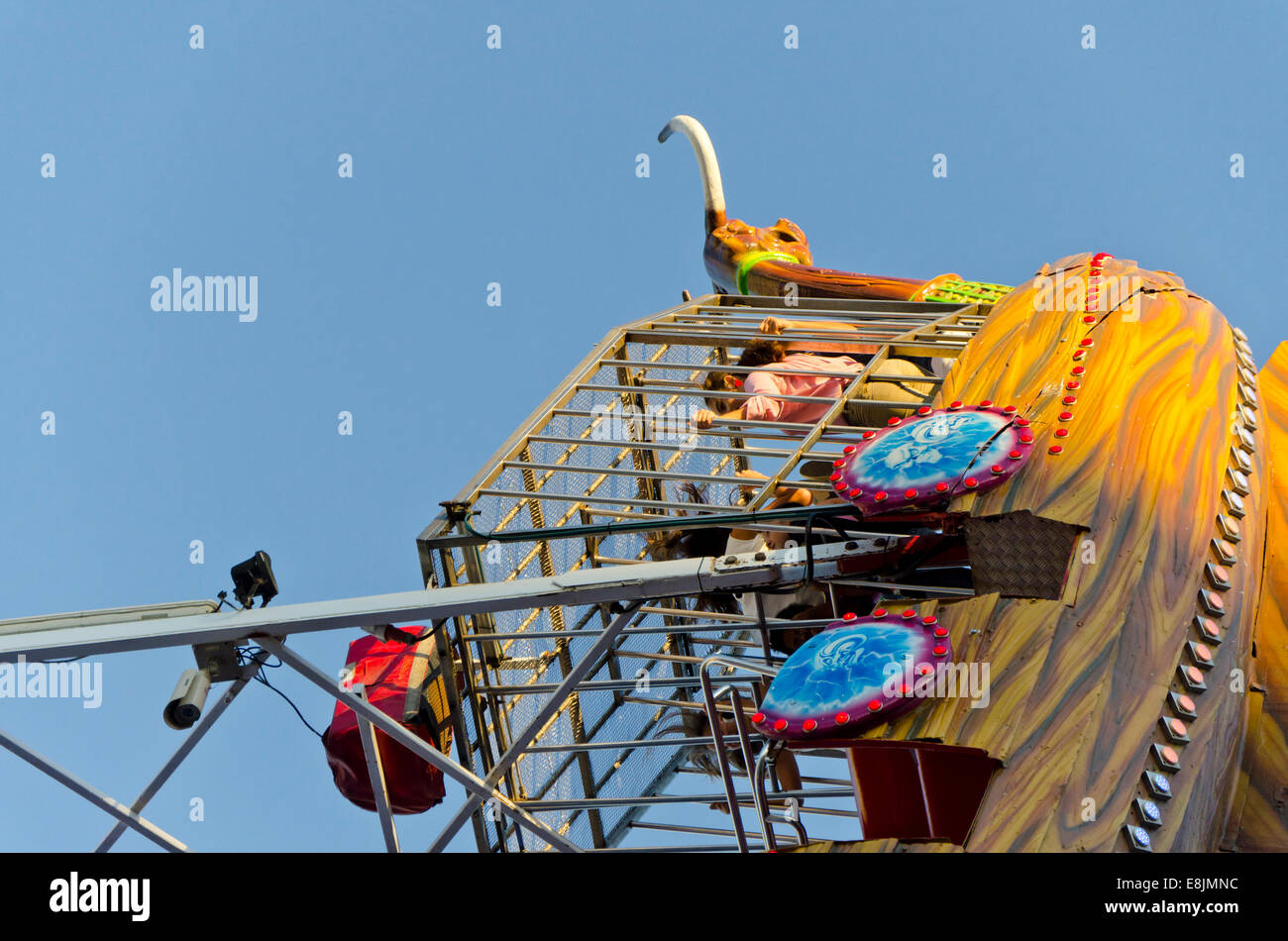 Children inside a cage of a pirate ship, amusement ride, gondola, in horizontal position at annual fair. Fuengirola, Spain. Stock Photo