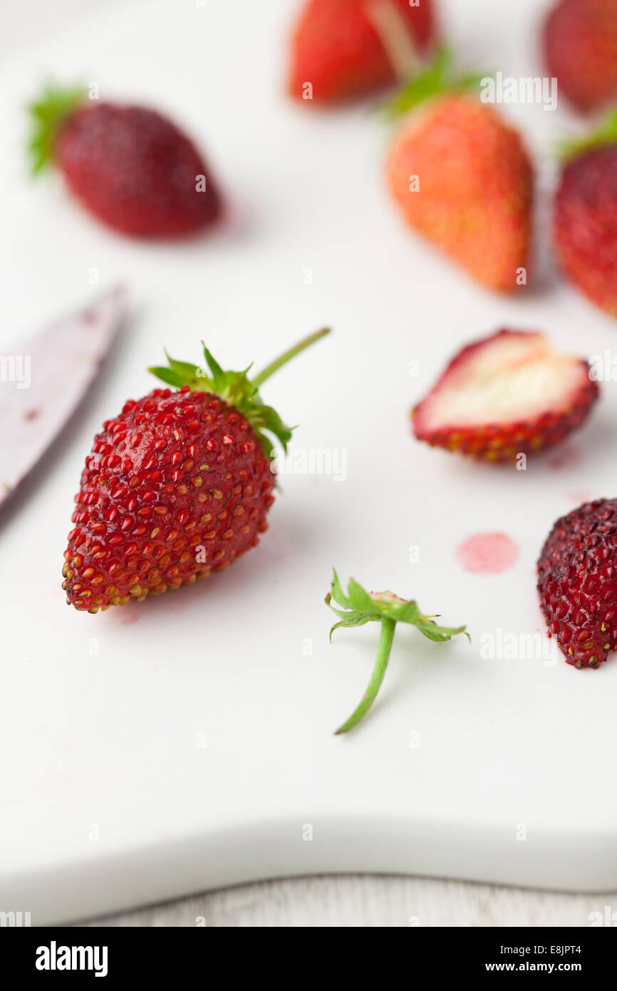 Homegrown Alpine Strawberries on Chopping Board Stock Photo