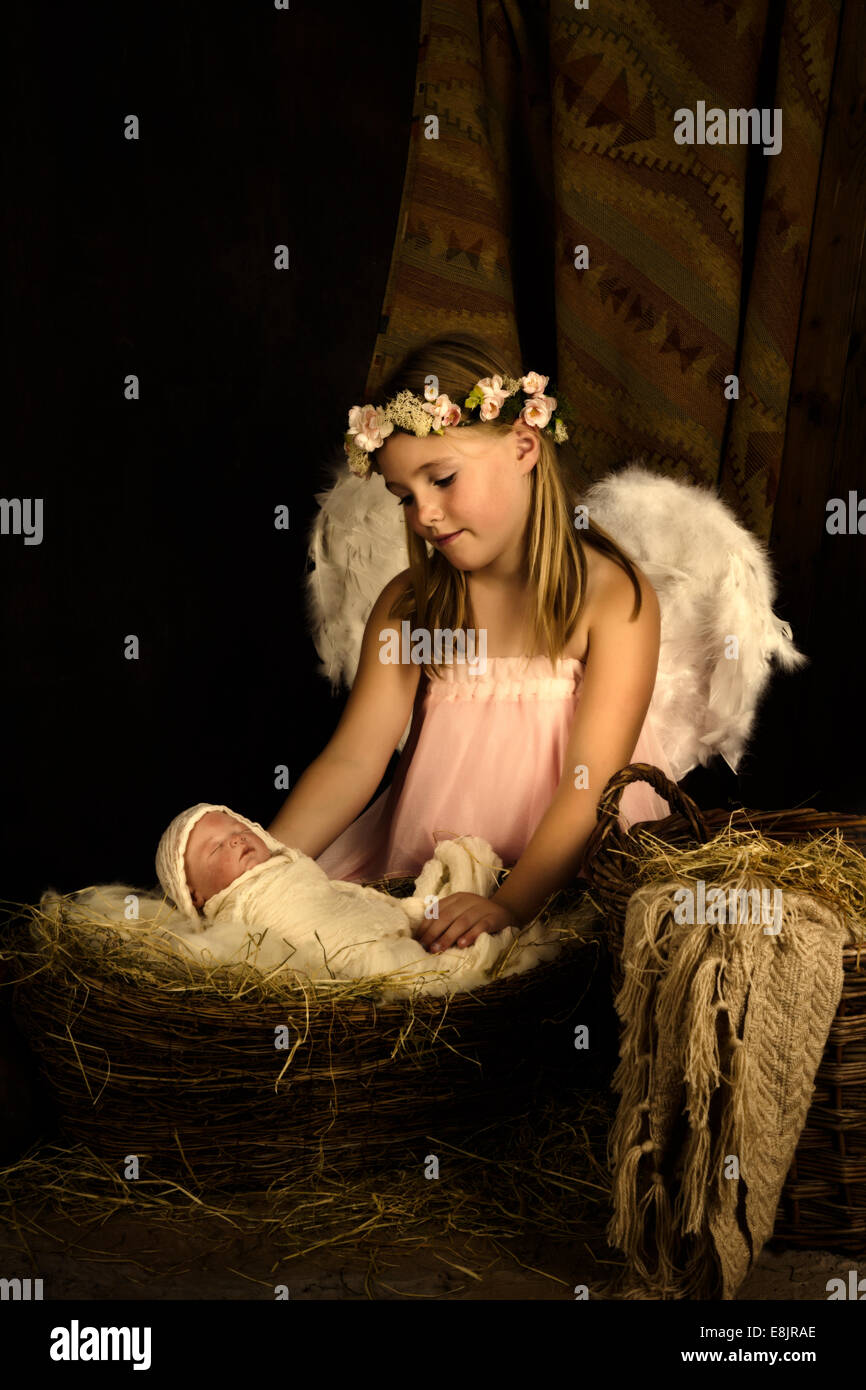 Pink little girl playing an angel in a Christmas nativity scene with a