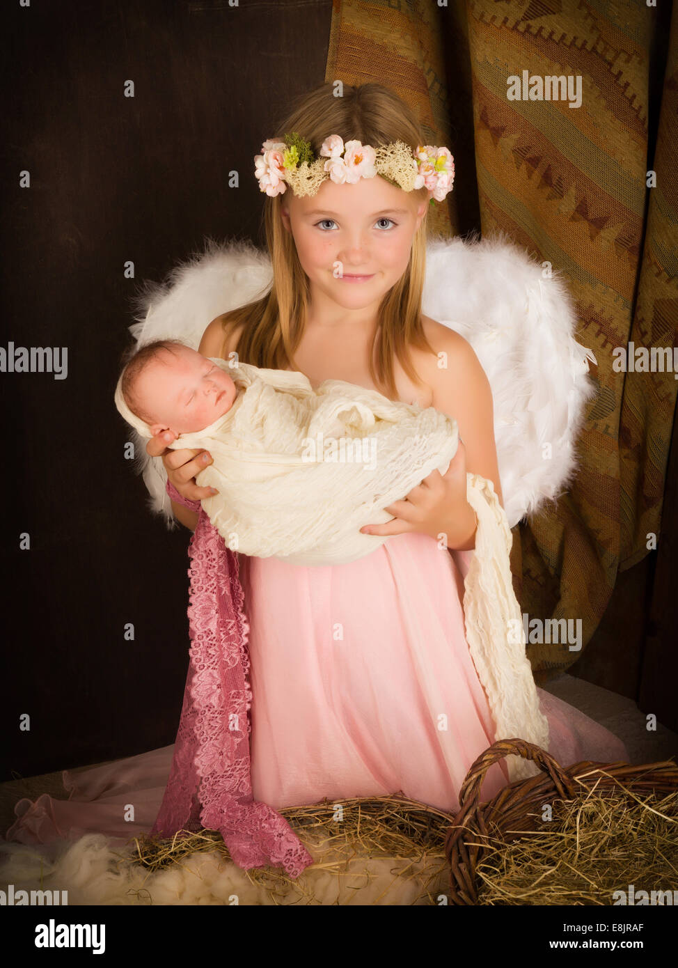 Pink little girl playing an angel in a Christmas nativity scene with