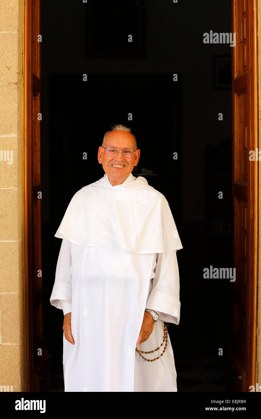 Dominican priest at the door of his church Stock Photo
