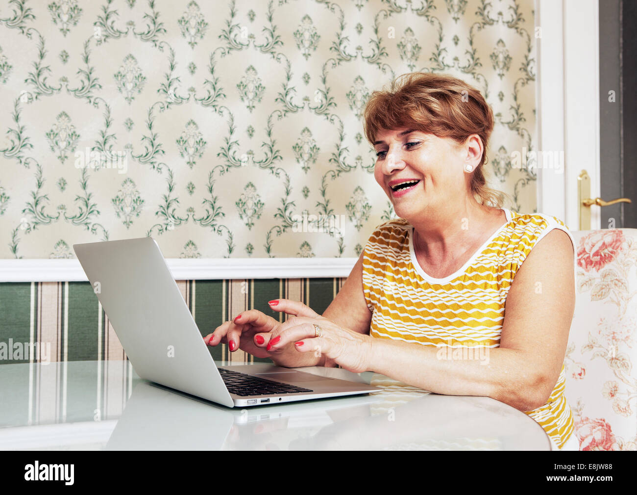 Mid aged woman using laptop Stock Photo